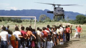 Refugees wait in line to be evacuated by a US Army UH-60A Blackhawk